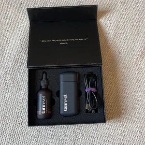 Tanrevel brun utan sol kit - Säljer ett Tanrevel brun utan sol kit som innehåller en applikator, en flaska med brun utan sol vätska och en USB-kabel för laddning. Perfekt för en jämn och naturlig solbränna året runt. Kommer i en stilren svart förpackning.