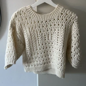 Vit stickad tröja - Säljer en söt vit virkad tröja med ett luftigt mönster. Tröjan har trekvartsärmar och en rund halsringning. Väldigt snygg att styla med!💗