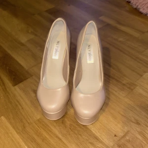 Beige pumps från NLY Shoes - Snygga beige pumps från NLY Shoes med hög klack och rund tå. Perfekta för att ge lite extra höjd och stil till din outfit. Tillverkade i syntetmaterial med en elegant finish.