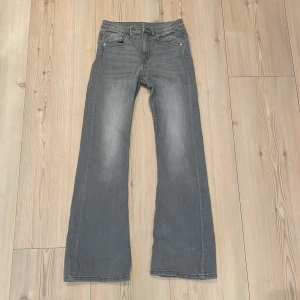 Grå bootcut jeans från Kappahl - Snygga grå bootcut jeans från Kappahl i mid waist-modell. Perfekta för en avslappnad stil med en klassisk touch. De har en bekväm passform och är tillverkade i ett slitstarkt material.