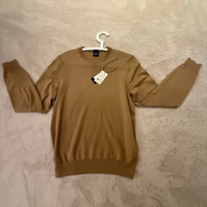 Beige tröja från BOSS - Säljer en stilren beige tröja från BOSS. Tröjan är storlek s och i nyskick med lapp  kvar. Inköpt från johnells för 1300 