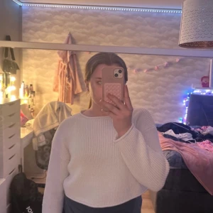 Vit stickad tröja - Säljer en stilren vit stickad tröja med croppad passform. Tröjan har långa ärmar och en rund halsringning, perfekt för en avslappnad look. Passar bra till både jeans och kjol. Perfekt för kyligare dagar!