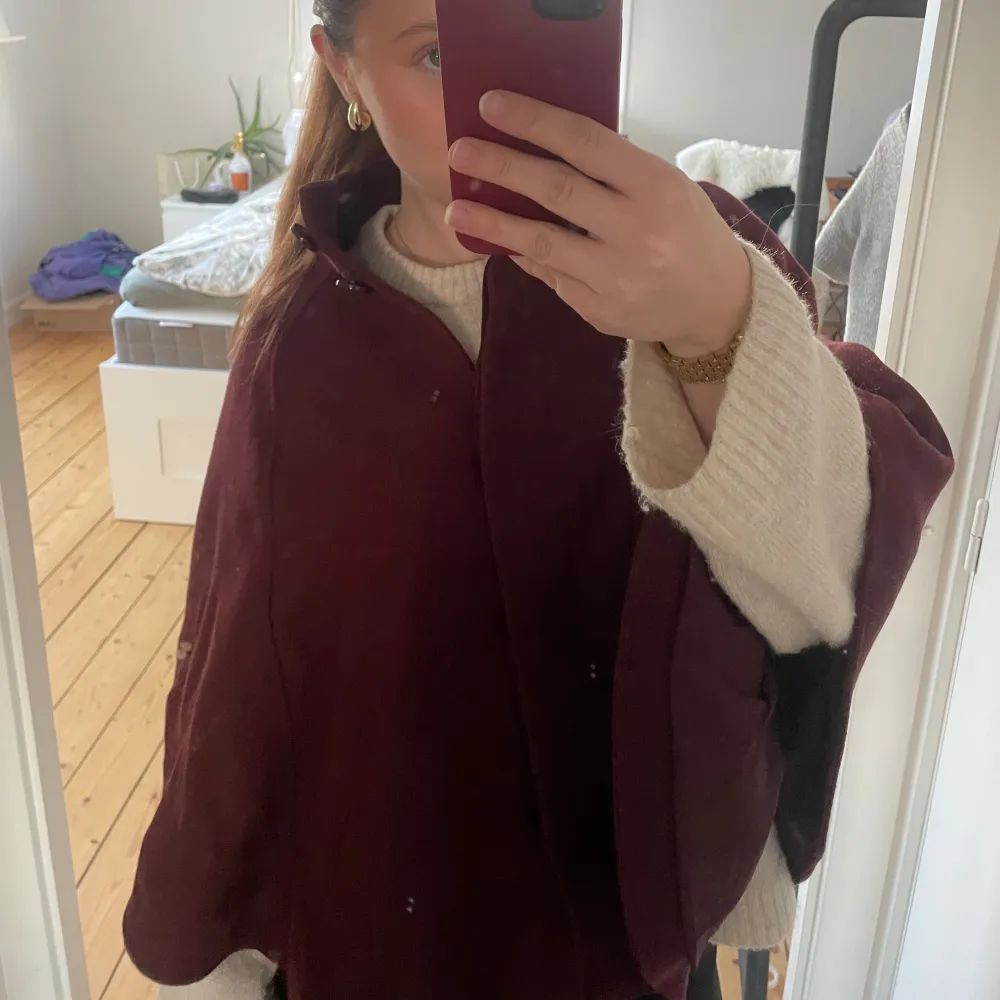 ❣️❣️❣️SÄLJER ÄVEN I SVART❣️❣️❣️Säljer en elegant vinröd kappa med en stilren design. Perfekt för kyligare dagar och ger en sofistikerad look. Den har en lös passform och är långärmad, vilket gör den bekväm och lätt att bära över andra plagg. Passar xs och s samt m. Takit.