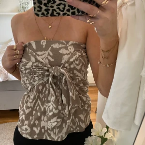 Beige mönstrad kjol/topp med knyt - Säljer en snygg beige kjol/topp med ett unikt mönster i vitt. Klädesplagget är en kjol, men är skitsnygg som en topp också, som jag visar på bilderna ⭐️⭐️jättesnyggt plagg  till sommaren eller våren! 🌸 