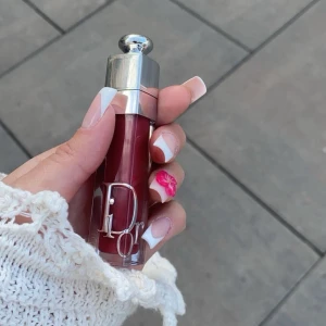 Rött, rosa  läppglans från Dior + klänning - Snyggt rött läppglans från Dior med en elegant silverfärgad kork. Perfekt för att ge läpparna en glansig och fyllig look. Kompakt och lätt att ta med i väskan. Använd 1 gång 