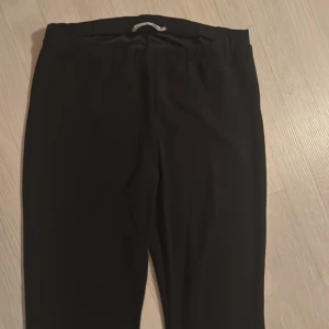 Svarta utsvängde byxor  - Svarta utsvängda byxor. Snyggt utsvängda ben och stretchigt material som ger en bekväm känsla. Perfekta för dig som gillar en stilren och trendig look.