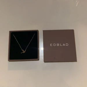 Fågelhalsband i silver från Edblad - Snyggt halsband från Edblad med en tunn silverkedja och ett stilrent hänge i form av en fågel. Kommer i originalask, perfekt som present eller för att lyfta din outfit med en enkel men elegant detalj. Har inte använt den för att jag är guldtjej 😭