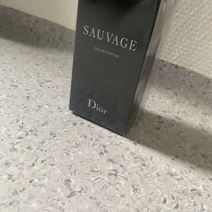 Dior Sauvage Eau de Parfum 100ml - Den mest eftertraktade herrparfymen i världen – Dior Sauvage Eau de Parfum 100ml.  Djup, maskulin doft med noter av bergamott, vanilj och ambroxan.  ✅ Oöppnad  ✅ Eau de Parfum – håller länge ✅ Butikspris: 1685 kr   📦 Spårbar frakt eller möte  🎁 Perfekt present eller unna dig själv lite lyx