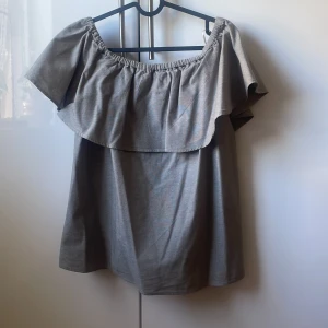 Grå/Grön offshoulder topp från Apricot - Snygg grå/grön  offshoulder topp från Apricot med bred volang runt axlarna. Toppen har en avslappnad passform 