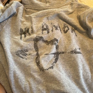Grå Mi Amor hoodie  - Grå mi amor hoodie, med lite suddad text, ny pris 1500, pris kan diskuteras 