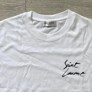 Saint Laurent t-shirt - Ny och Oanvänd vit t-shirt från Saint Laurent med logotyp-tryck både fram och bak. Perfekt för dig som vill ha en snygg look! Kom med frågor!😁