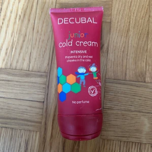 Decubal Junior Cold Cream 100 ml - Decubal Junior Cold Cream är en intensiv, parfymfri ansiktskräm för barn som skyddar mot torra och röda kinder i kylan. Tuben är röd med färgglada hexagoner och illustrationer av barn. Innehåller 100 ml och har hög fetthalt för extra skydd.