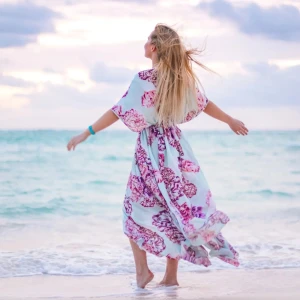 Blommig långklänning By Malina - Superfin långklänning från By Malina i ljusblått med stora rosa och blommor. Klänningen har v-ringning, korta vida ärmar och resår i midjan för en snygg siluett. Perfekt för sommarens alla tillfällen! Storlek M.  Inga anmärkningar