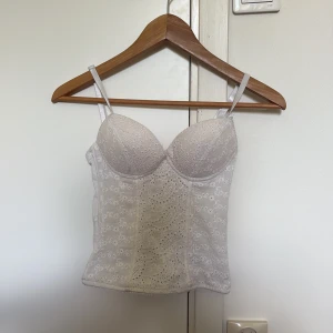 Vit korsett topp  - Superfin vit mönstrad korsett topp. Perfekt till utekväll! Har tre bredder på spännet. Kupan är A