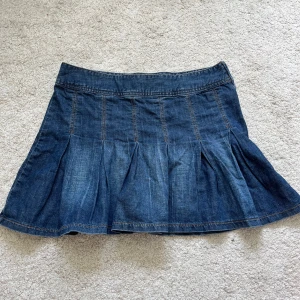 Jeanskjol - Jeanskjol i mörk tvätt med volanger längst ner! Passar 36/38 och jag skulle säga att den är midwaist.  Finns en dragkedja på sidan. Skriv om ni har frågor❣️