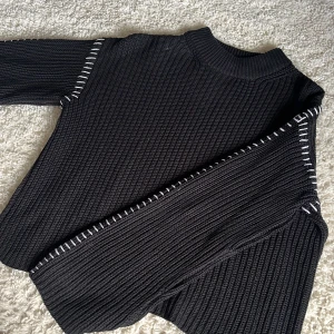 Svart stickad tröja med vita sömmar - Säljer denna snygga svarta tröjan med vita sömmar!🤍 Perfekt för hösten! I strl S och i jättefint skick. Säls pga av att jag inte använder längre.