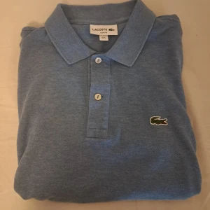 Lacoste Piké Slim Fit (S) - Säljer en ljusblå Lacoste Piké i väldigt bra skick. Pikén är Slim fit och passar perfekt för 170-175 cm. Nypris är ca 1200kr. Jag säljer för 350kr. (Pris kan diskuteras) 