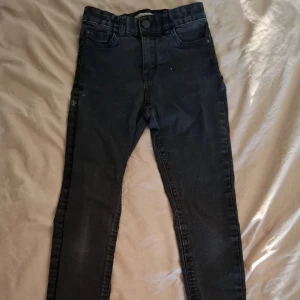 Svarta skinny jeans från Lindex - Säljer ett par svarta skinny jeans från Lindex, modell Selma. Jeansen har klassisk femficksdesign, hällor för bälte och smal passform hela vägen ner. Perfekta för dig som gillar en enkel och stilren look. 