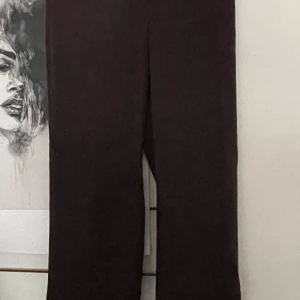 Bruna raka byxor från BikBok (Vilma) - Mörkbruna byxor från BikBok i rak modell. Byxorna har en klassisk passform med normal midja och är tillverkade i ett mjukt bomullsmaterial.