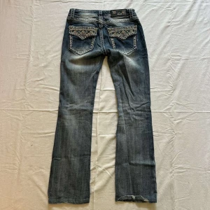 Lågmidjade bootcut jeans - Blå lågmidjade jeans med strass på fickorna. Innerbenslängd: 75cm, midja: 34cm💙
