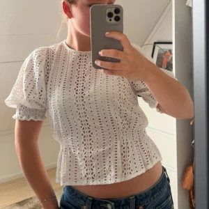 Vit broderad blus med puffärm - Superfin vit blus med broderade detaljer och korta puffärmar. Blusen kommer från hm men är slutsåld
