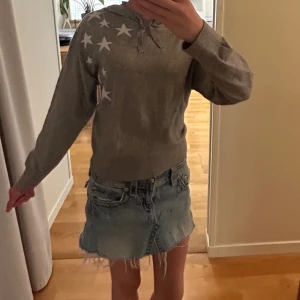 Grå hoodie med vita stjärnor - Grå hoodie med vita stjärnor på ena axeln och en stor stjärna på ryggen. Tröjan har huva med snörning och långa ärmar. Perfekt för dig som gillar en chill look. Mjuk och skön, passar till jeans eller kjol. Jag är 164cm och den passar ganska bra på mig ❤️kontakta vid frågor 🥰