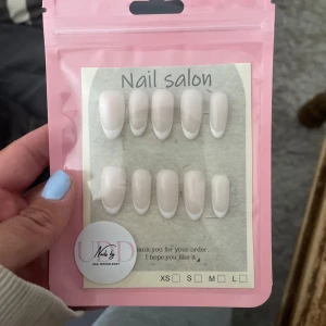 Franska lösnaglar i almondform - Snygga lösnaglar i klassisk fransk design med vit tipp och nude bas. Naglarna har en almondformad siluett och kommer i flera storlekar. Perfekt för dig som vill ha salongskänsla hemma.