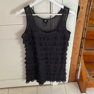 En volang klänning från Hm - En mörkblå volangklänning från Hm, i storlek s. Som är ganska kort men ändå rätt skön! 