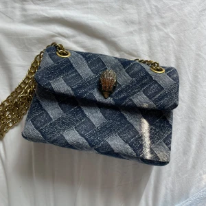 Kurt Geiger väska - Jättefin axelväska från Kurt Geiger i jeansmönstrat liknande tyg. Bra storlek, är mycket unik och ger en snygg touch till ens outfit