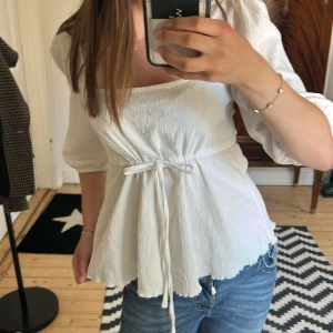 Vit blus med knyt och puffärm - Superfin vit blus med puffiga trekvartsärmar och knyt i midjan. Den är ifrån lager 157 och knappt använd och är som ny! Är i storlek M men skulle säga att den är som en S! Säljer för 70kr pris kan diskuteras!