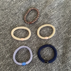 Fem hårsnoddar  - Säljer fem hårsnoddar som liknar kknekkis (men de är ej riktiga) i: beige, blå, lila och ett mönstrat i vinrött och gult. 