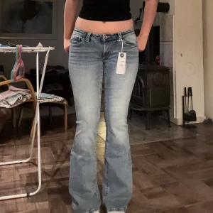 for real low waist jeans tall jeans från Gina Tricot Young 14+  - Säljer ett par snygga blå flare jeans i vintage wash med låg midja och normal passform. Bakfickorna har strassdetaljer som ger extra edge. Jeansen är i stretchigt denim och passar dig som är lång. Jag är 177 och dom är långa på mig. Denna färg är slutsåld i storlek M på nätet. På bilderna har jag på mig dom i L dom i M är inte ens öppnade utan dom är helt nya inte ens provade🥰 passar inte priset kom med förslag!💗