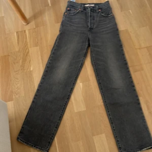 Levi's Ribcage Straight Ankle jeans svart - Säljer ett par Levi's Premium Ribcage Straight Ankle jeans i svart tvätt. Hög midja, raka ben och klassiska femficksdetaljer. Jeansen är i kraftig bomullsdenim och har snygg vintagekänsla med Levi's ikoniska bakfickor och läderpatch.