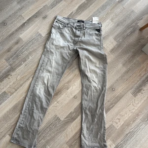 Grå Replay jeans straight fit - Snygga grå jeans från Replay med klassisk femficksdesign och raka ben. Jeansen har diskreta sömmar och Replay-logga vid fickan. Perfekta för dig som gillar en clean och stilren look. Materialet är mjukt och bekvämt jeans. Storlek 166cm vilket passar dom som har 30W och 32L
