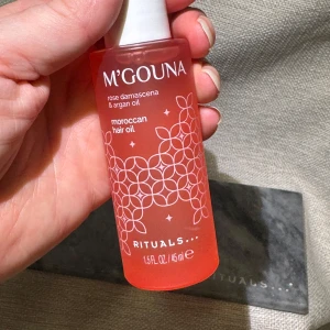 Ny! M'Gouna Moroccan Hair Oil Rituals - Ny! M'Gouna Moroccan Hair Oil från Rituals med ros damascena och arganolja. Kommer i en snygg rosa glasflaska med vit pump och dekorativt mönster. Innehåller 45 ml (full size) återfuktande olja som ger glans och mjukhet till håret. Slutsåld limited edition, passa på!
