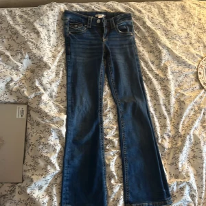 Blå bootcut jeans från Gina Tricot - Snygga blå jeans från Gina Tricot i storlek 152. Modellen har bootcut-ben, låg midja