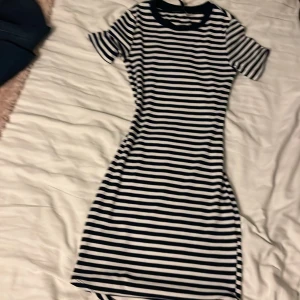 Randig kortklänning från H&M Divided - Säljer en blåvitt randig kortklänning från H&M Divided i storlek 38. Klänningen har rund halsringning, korta ärmar och en figurnära passform. Perfekt för dig som gillar en enkel men snygg stil.Säljer endast för 99kr!