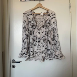 Odd molly blus  - Säljer en otroligt vacker blus i beige, med detaljer i svart, mörkgrått och en ljusrosa nyans. Från märket Odd Molly i storlek 2 som ungefär motsvarar en Storlek M. Mycket fint skick, jag hittar inga synlig anmärkningar eller defekter. 