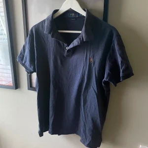 Ralph Lauren Piké - Ralph lauren Piké i en mörkblå färg, använd men i ett fint skick. Storlek M men sitter som S/XS🙌