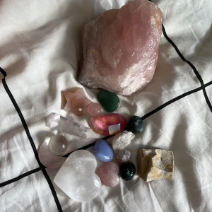 Samling av kristaller och stenar - Säljer en samling kristaller och stenar i olika former och färger, bland annat rå rosenkvarts, hjärtformad selenit, stjärnformad agat, grön aventurin, klar kvarts, regnbågsskimrande kristall och blå kalcit. Perfekt för dig som älskar kristaller och vill ha en färgglad mix till din samling.