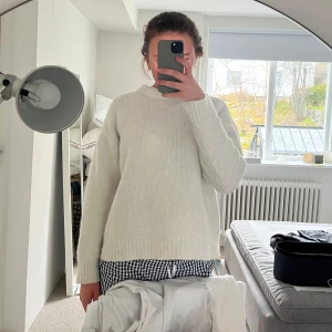 Vit stickad tröja - Mysig beige stickad tröja med rund halsringning och långa ärmar. Perfekt för lager-på-lager och passar till både jeans och kjol. Enkel och stilren design som funkar till många olika outfits.