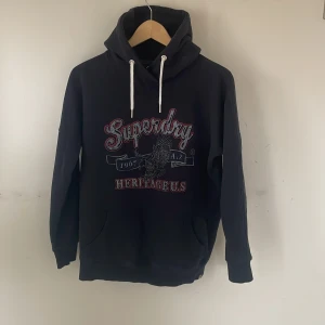 Superdry hoodie - Säljer nu en ny riktigt fet hoodie från Superdry! Den har en sjukt snyggt tryck på magen och vita snören för en fin kontrast😊den är i stoleken S och har inga defekter!  hör av dig vid midnatt fråga o fundering!💫💫