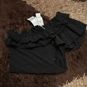 One off the shoulder svart zara topp - Säljer en one off the shoulder svart zara topp som är helt ny och oanvänd, säljs för samma pris som köptes alltså 199kr. Det är en storlek M med orginala prislappen på den.
