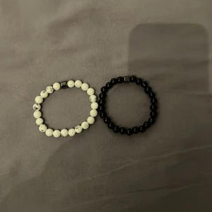 Två pärlarmband i svart och vit marmor - Säljer två stilrena armband med pärlor – ett i vit marmorlook och ett i helsvart. Båda har elastiskt band och passar perfekt som accessoar till din outfit. Snygga att bära tillsammans eller var för sig!