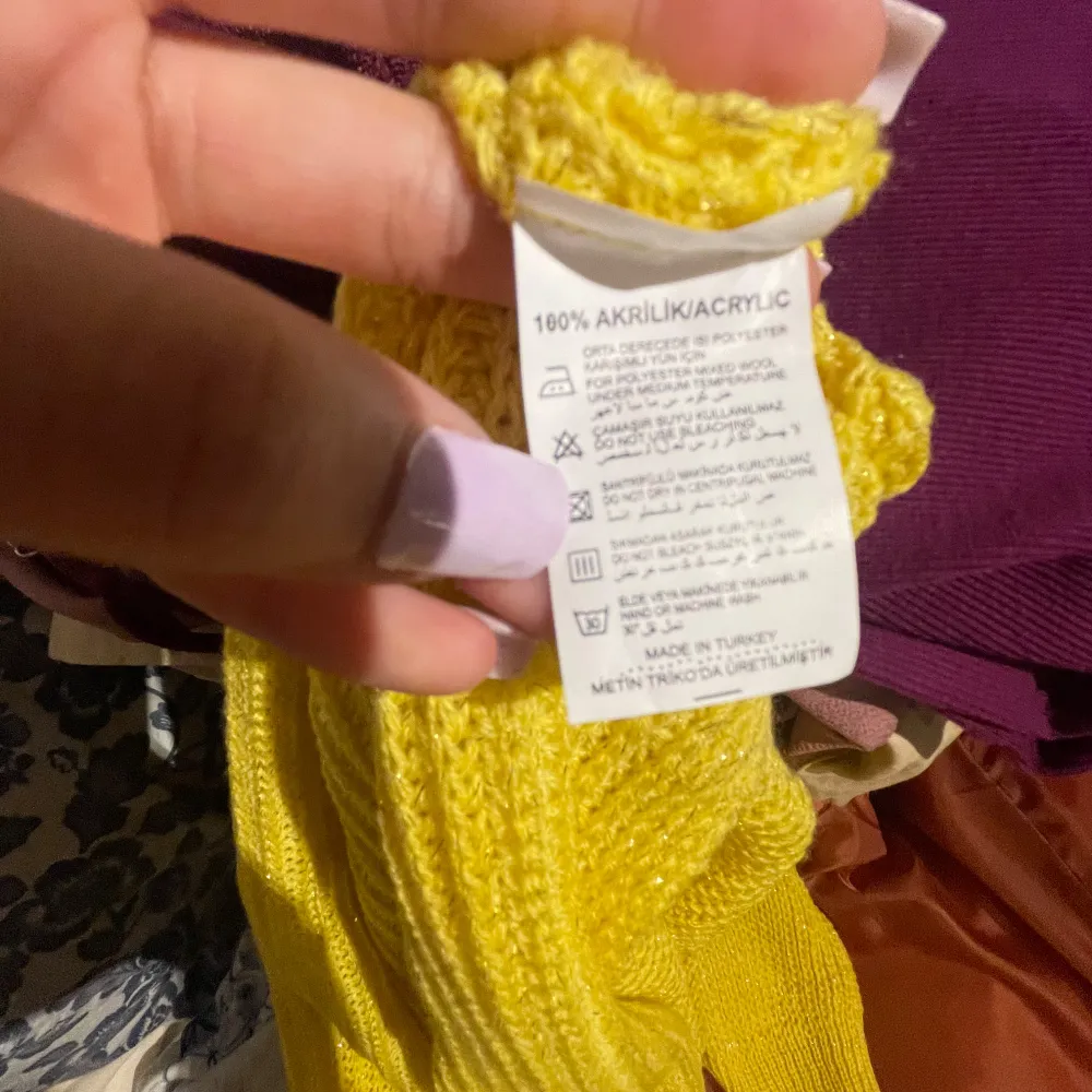 Säljer en solgul stickad tröja med v-ringad hals. Tröjan är mjuk och har en avslappnad passform med långa ärmar. Perfekt för att liva upp garderoben med lite färg! Materialet är 100% akryl.. Neuleet.