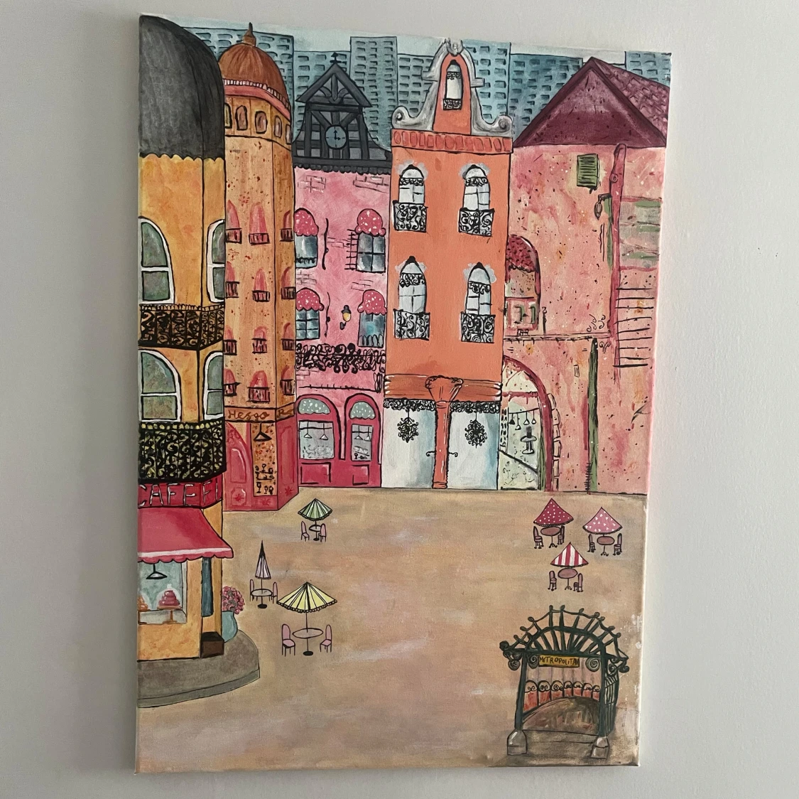 Målning av stadstorg med café och pastellfärgade byggnader