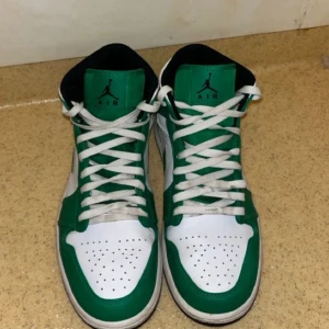 Nike Air Jordans i grönt och vitt - Säljer ett par Nike Air Jordans med klassisk siluett i grönt och vitt. Skorna har snörning, rund tå och vit sula. Perfekta för dig som gillar streetwear och vill sticka ut med färg. Ikonisk Jordan-logga på sidan. Jag har inte paket!