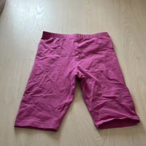 Rosa cykelshorts från H&M - Säljer ett par rosa cykelshorts från H&M i stretchigt material. De har en enkel design utan fickor eller detaljer och resår i midjan för skön passform. Perfekta för träning eller sommarens aktiviteter.