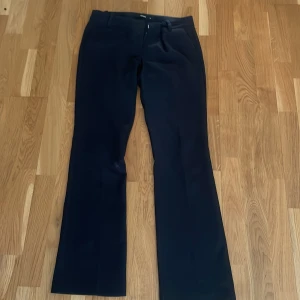 Svarta kostymbyxor från Bik Bok - Klassiska svarta kostymbyxor från Bik Bok med normal passform och raka ben. Byxorna har hällor för bälte och stängs med dragkedja och hake. Perfekta till en stilren look.