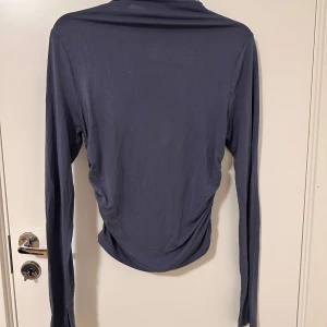 Mörk Grå/blå långärmad topp - Säljer en mörkgrå långärmad topp med mjukt och tunt material. Den är super skön o ligger i underbar kondition. 